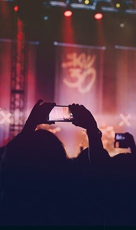 Crowd at a concert taking photos with smartphones, capturing the vibrant stage lights and atmosphere, reflecting the energy of live music events at thebandbuilder-com.preview-domain.com